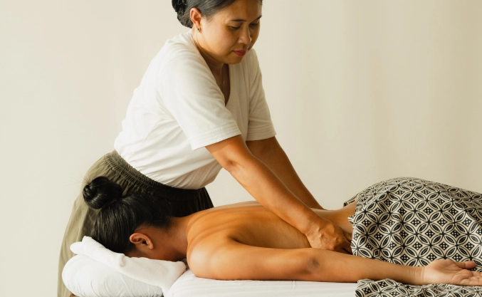 Therapist performing a Balinese spa massage treatment at Yuna Wellness